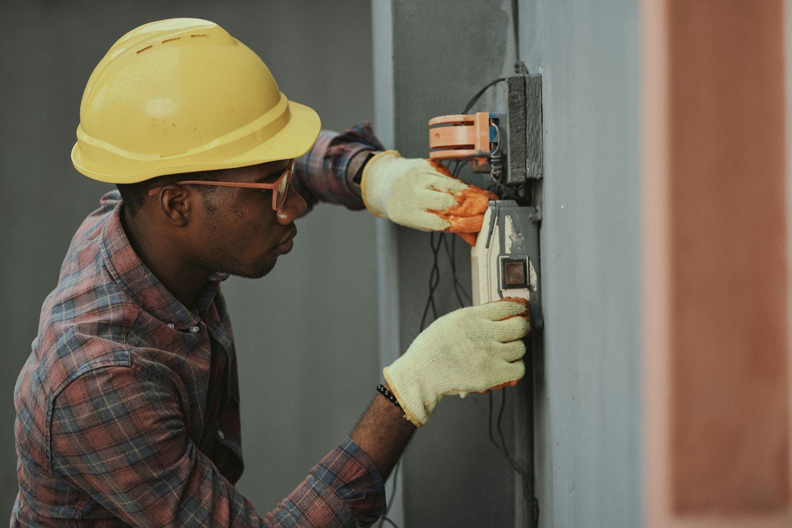 Technician testing the electrical connections of an AC unit